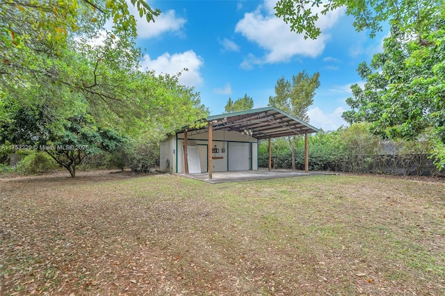 view of yard with an outdoor structure, fence, and a detached garage