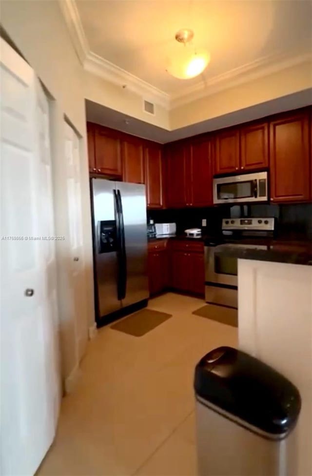 kitchen featuring dark countertops, dark brown cabinets, visible vents, crown molding, and appliances with stainless steel finishes