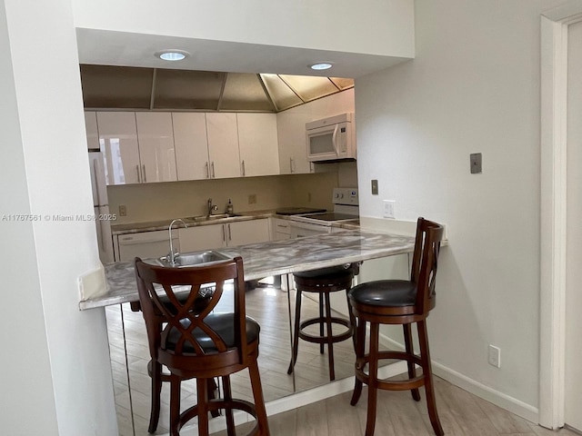 20281 E Country Club Dr Unit 810, Aventura, FL 33180 - kitchen featuring white cabinets, white appliances, baseboards, a sink, and a breakfast bar area