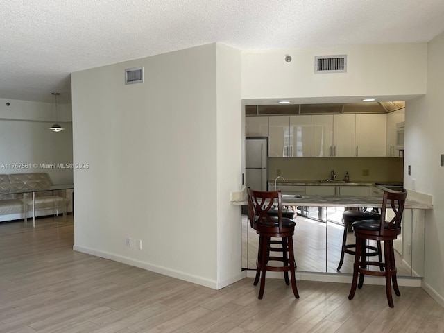 20281 E Country Club Dr Unit 810, Aventura, FL 33180 - kitchen featuring a sink, visible vents, light wood-style floors, and freestanding refrigerator