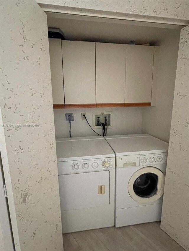 20281 E Country Club Dr Unit 810, Aventura, FL 33180 - clothes washing area featuring light wood finished floors, washing machine and dryer, and cabinet space
