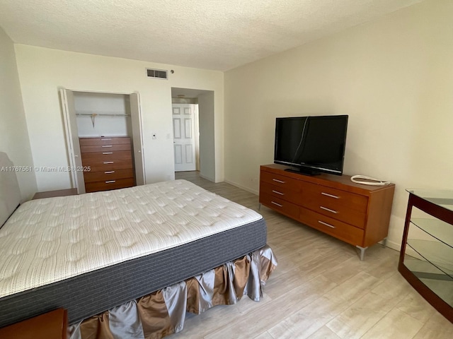20281 E Country Club Dr Unit 810, Aventura, FL 33180 - bedroom with baseboards, a textured ceiling, light wood-style floors, visible vents, and a closet