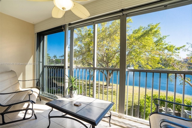 sunroom featuring a water view and ceiling fan