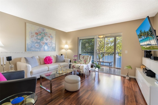 living area with wood finished floors, baseboards, and a textured ceiling