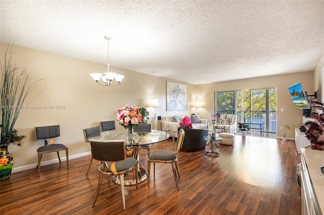 dining room with a notable chandelier, wood finished floors, baseboards, and a textured ceiling