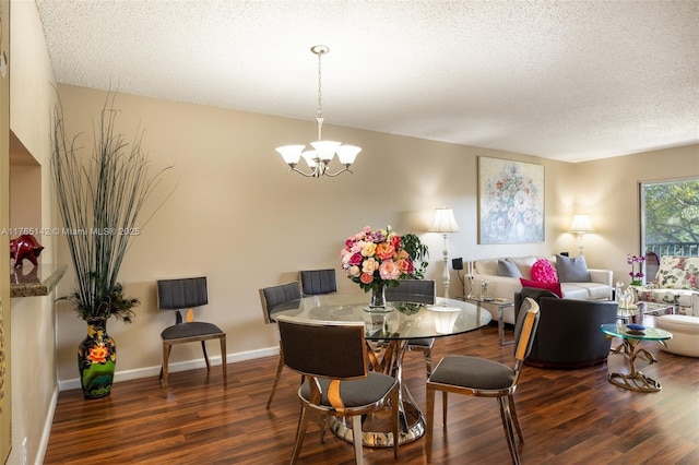 dining room featuring a chandelier, baseboards, a textured ceiling, and wood finished floors