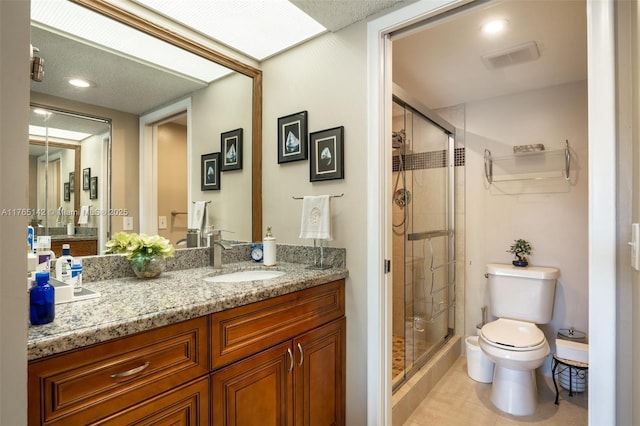 full bathroom featuring visible vents, toilet, a stall shower, and vanity
