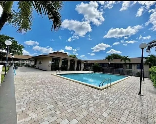 pool with a patio and fence