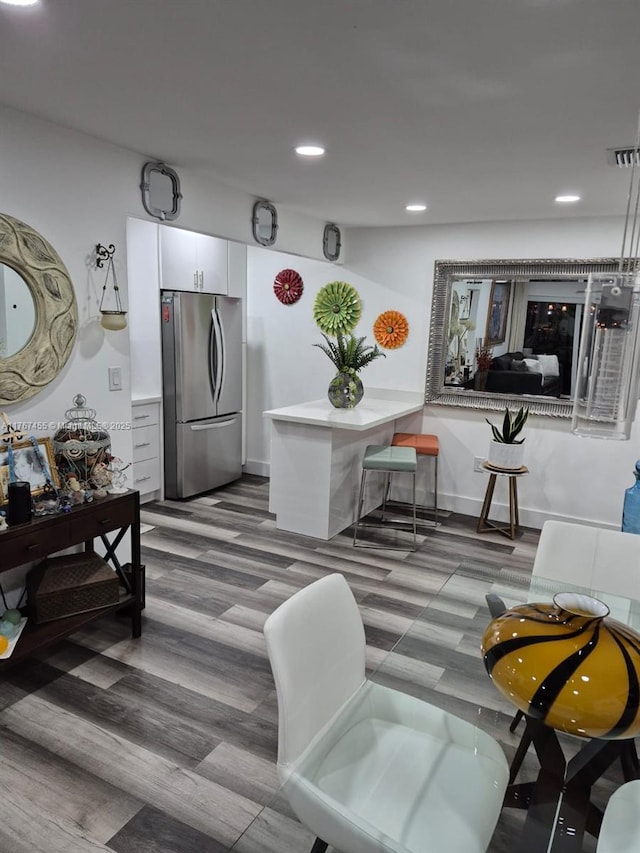 living area featuring recessed lighting, visible vents, and wood finished floors