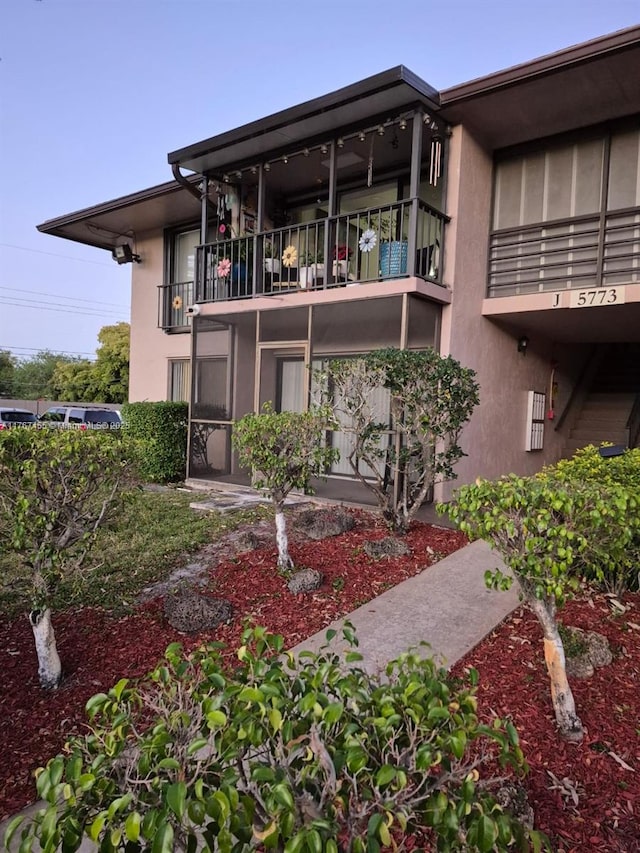 rear view of property with a balcony and stucco siding