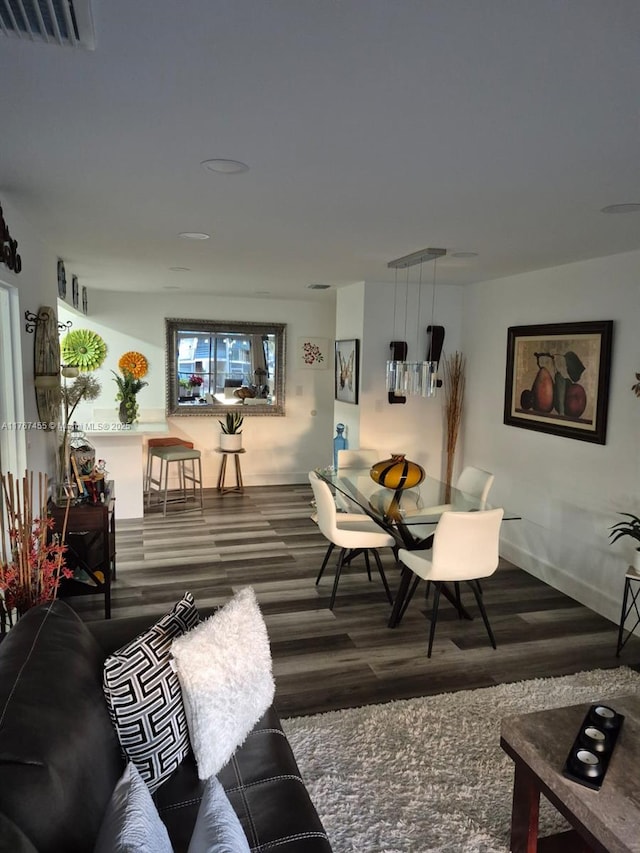 living area featuring visible vents and wood finished floors