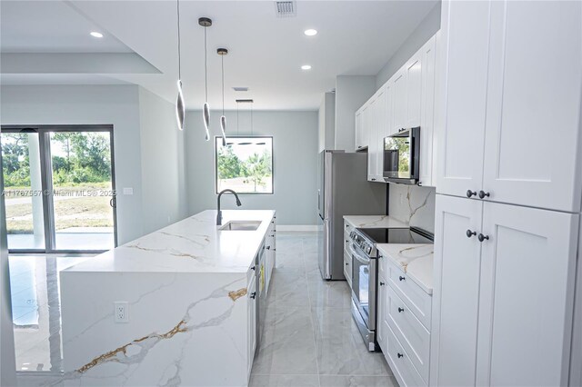 1254 S Ellipse St E, Lehigh Acres, FL 33974 - kitchen with visible vents, a kitchen island with sink, recessed lighting, a sink, and appliances with stainless steel finishes