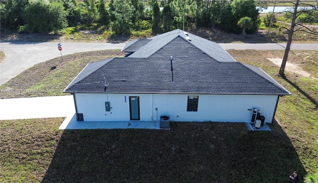 1254 S Ellipse St E, Lehigh Acres, FL 33974 - back of property with a yard, roof with shingles, and central air condition unit
