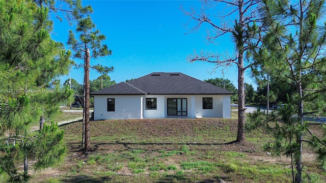 1254 S Ellipse St E, Lehigh Acres, FL 33974 - back of property with roof with shingles and stucco siding
