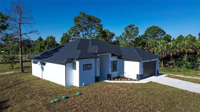 1254 S Ellipse St E, Lehigh Acres, FL 33974 - view of front of house featuring an attached garage, a shingled roof, stucco siding, and a front yard