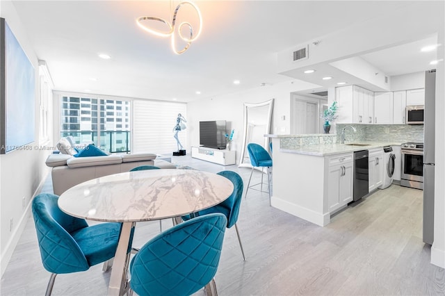 2501 S Ocean Dr Unit 536, Hollywood, FL 33019 - kitchen with stainless steel appliances, open floor plan, white cabinetry, light wood finished floors, and recessed lighting
