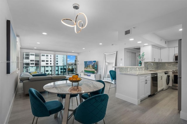dining space with light wood-style flooring, recessed lighting, visible vents, and baseboards