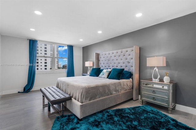 bedroom with recessed lighting, wood finished floors, and baseboards