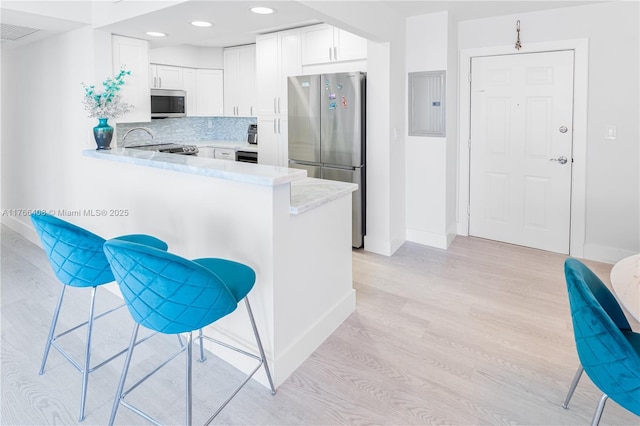 2501 S Ocean Dr Unit 536, Hollywood, FL 33019 - kitchen featuring appliances with stainless steel finishes, electric panel, light wood-type flooring, light countertops, and a peninsula