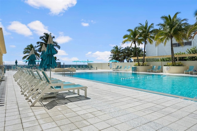 pool with a patio area and fence