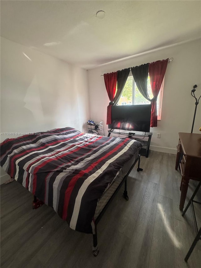 bedroom featuring baseboards and wood-type flooring