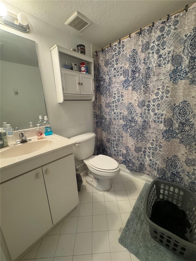 full bathroom featuring visible vents, toilet, vanity, tile patterned floors, and a textured ceiling