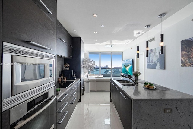 900 Biscayne Blvd Unit 4504, Miami, FL 33132 - kitchen with modern cabinets, appliances with stainless steel finishes, dark cabinetry, a kitchen island with sink, and a sink