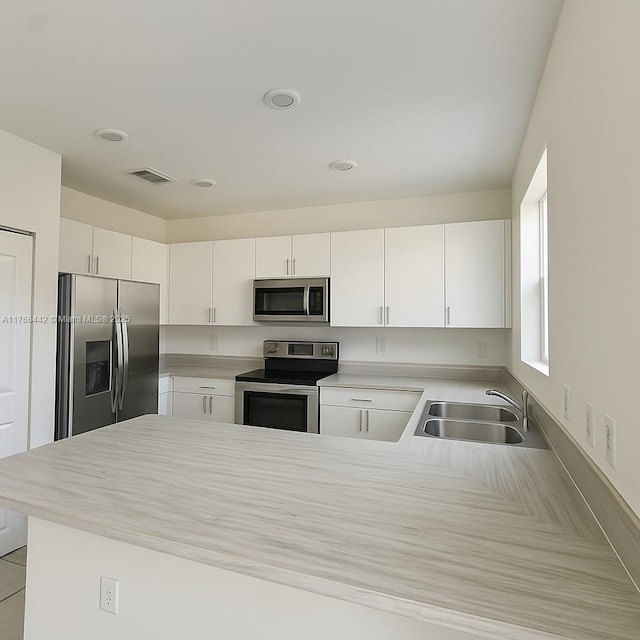 2737 SE 17th St, Homestead, FL 33035 - kitchen featuring appliances with stainless steel finishes, a sink, a peninsula, light countertops, and recessed lighting