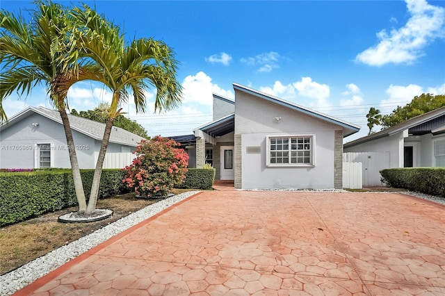 view of front of house with a gate, fence, and stucco siding