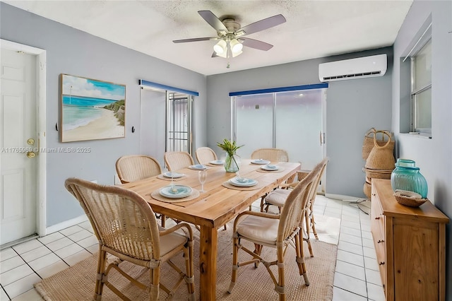 dining space featuring a wall mounted AC, a textured ceiling, light tile patterned floors, baseboards, and ceiling fan