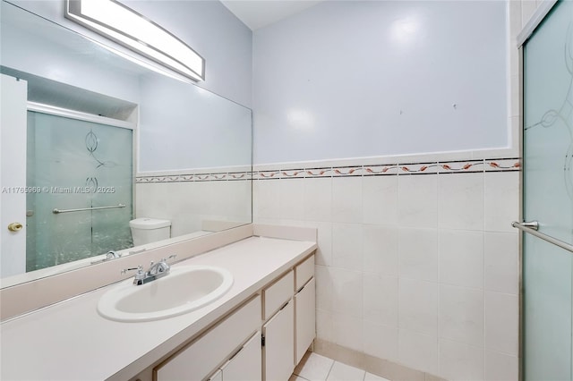 full bathroom featuring tile patterned floors, a shower stall, tile walls, and toilet