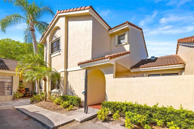mediterranean / spanish-style house featuring a tile roof and stucco siding