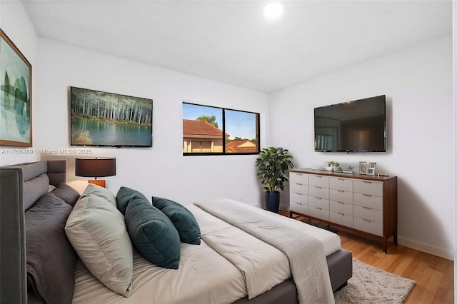 bedroom with baseboards and wood finished floors