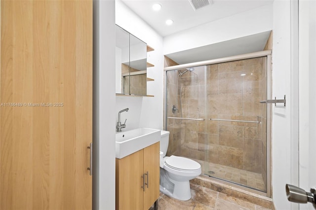 full bathroom featuring visible vents, a shower stall, toilet, and vanity