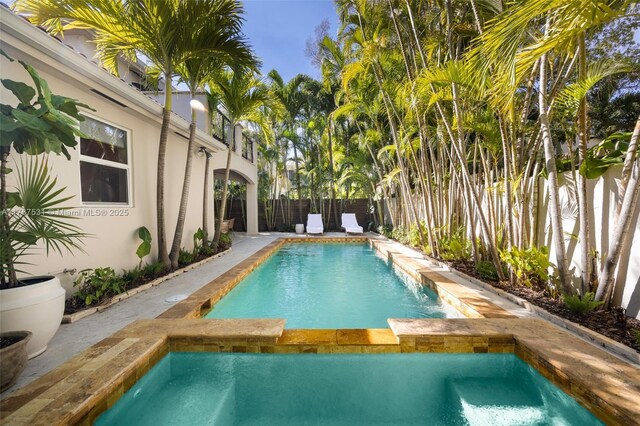 3120 Virginia St Unit 3120, Miami, FL 33133 - view of swimming pool featuring a pool with connected hot tub and a fenced backyard