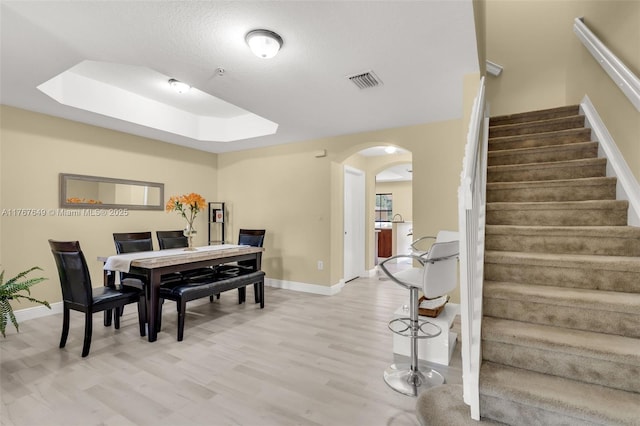 983 SW 143rd Ave Unit 1403, Pembroke Pines, FL 33027 - dining room with arched walkways, light wood-style floors, stairway, and a tray ceiling