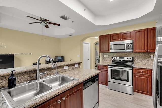 983 SW 143rd Ave Unit 1403, Pembroke Pines, FL 33027 - kitchen with appliances with stainless steel finishes, a tray ceiling, a sink, a ceiling fan, and arched walkways