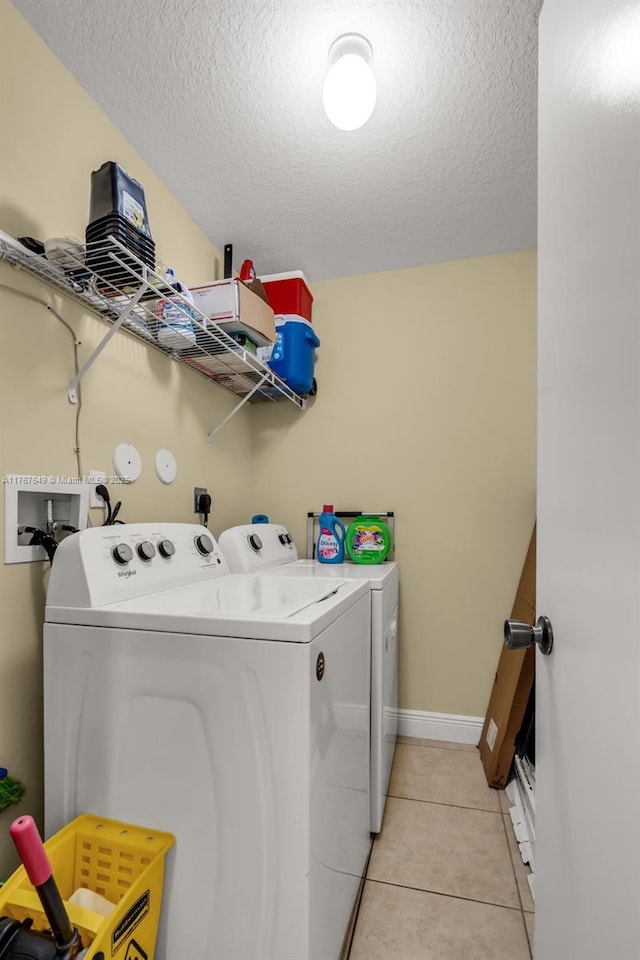 983 SW 143rd Ave Unit 1403, Pembroke Pines, FL 33027 - laundry room featuring separate washer and dryer, a textured ceiling, and light tile patterned flooring