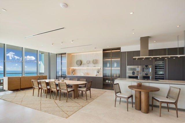 dining area with a water view and a wall of windows