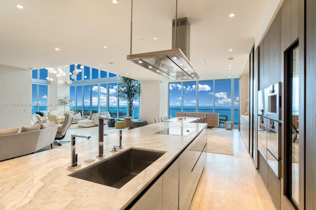 kitchen featuring modern cabinets, island range hood, black electric stovetop, and open floor plan