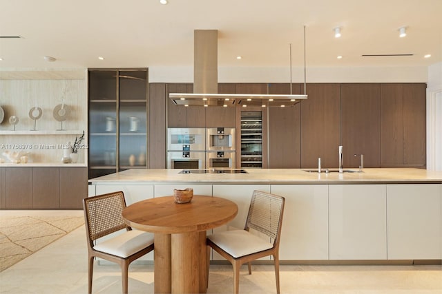kitchen with a sink, modern cabinets, double oven, black electric stovetop, and light countertops