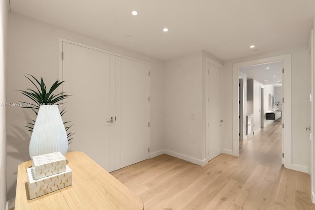 foyer entrance featuring baseboards, light wood-style flooring, and recessed lighting