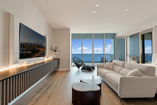 living area with floor to ceiling windows, wood-type flooring, and recessed lighting