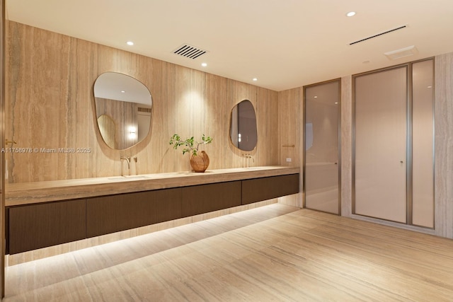 full bathroom featuring double vanity, wood finished floors, and visible vents