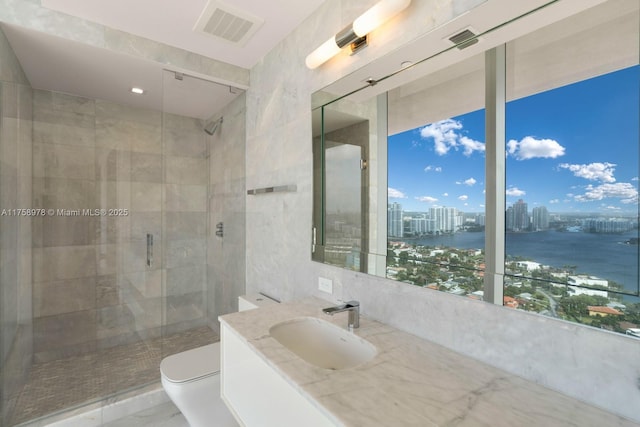 bathroom featuring visible vents, toilet, a stall shower, and a view of city