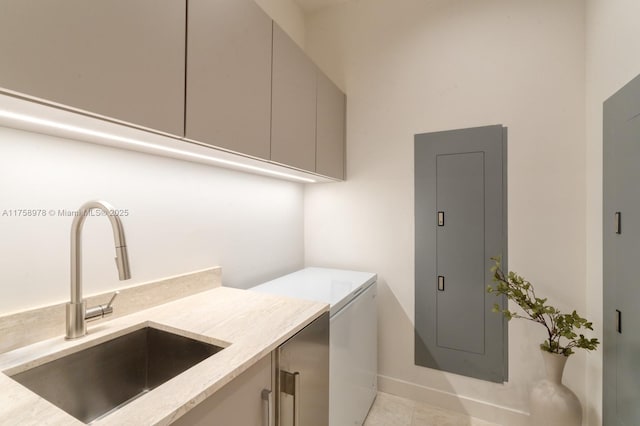clothes washing area with washer and clothes dryer, a sink, electric panel, cabinet space, and baseboards