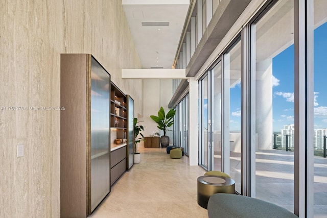 hallway with visible vents and a towering ceiling