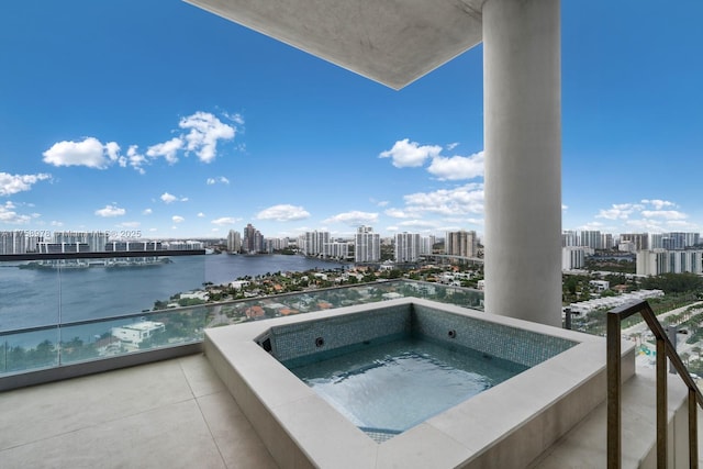 view of pool featuring a city view, a water view, and an in ground hot tub