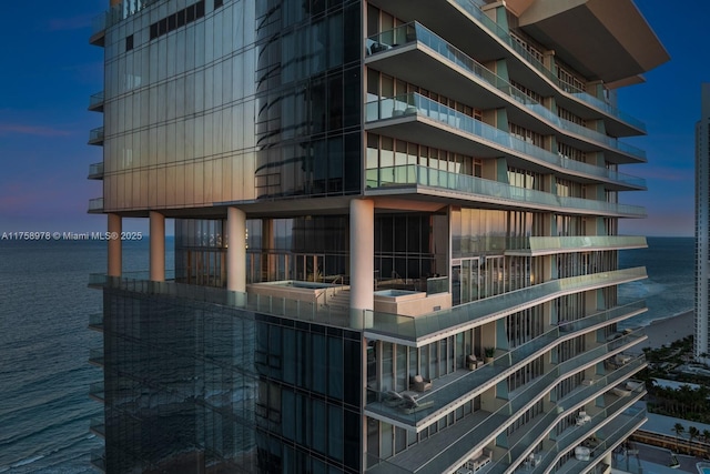 property at dusk with a water view