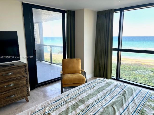10410 S Ocean Dr Unit 504, Jensen Beach, FL 34957 - bedroom featuring expansive windows, multiple windows, and view of water and beach